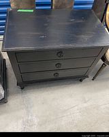 Front and top view of black three-drawer nightstand