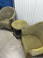 Two wicker armchairs and round side table grouped together