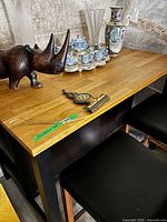 Front view of counter-height table showing wood top and black frame