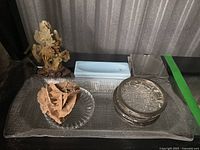 Overview of lot on glass tray showing mineral, sculpture, coasters