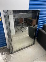 Front view of large rectangular mirror leaning against wall