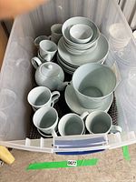 Overview of entire Maze Blue dinnerware set in storage bin