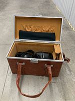 Open brown hard-sided camera case showing interior and contents