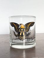 Front view showing eagle tattoo flash graphic on rocks glass