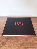 Front cover of black cloth hardcover with red monogram