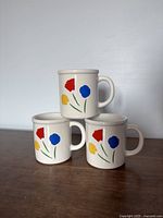 Three mugs stacked showing flower motif
