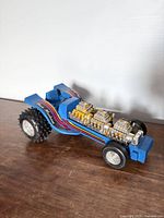 Left front three-quarter view showing body colour, decals, engine detail and wheels