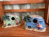 Two camper-style birdhouses, green and blue versions, shown front view