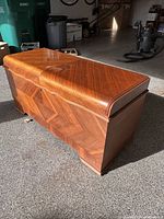 Front angled view of cedar chest showing veneer pattern and curved top