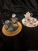 Overall view of both porcelain and resin miniature tea sets