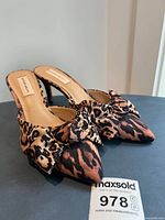 Pair of Antonio Melani leopard print satin mules showing side angle and bow detail