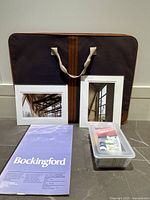 Full lot view with portfolio, photographs, paper pad and paint bin