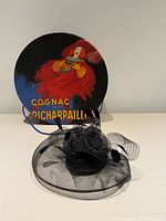 Fascinator displayed with illustrated round hat box