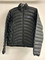 Front view of black Patagonia quilted puffer jacket on hanger