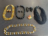 All items laid out, showing necklaces, earrings, brooch