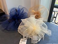 Overall view of two fascinator hats on stands