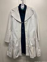 White Holt Renfrew coat over navy blouse showing both items