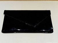Front view of black patent leather envelope clutch