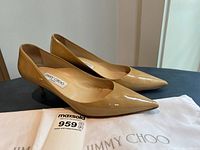 side view of both pumps showing patent leather finish and pointed toes