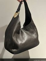 Front view of brown pebbled leather Michael Kors hobo bag showing overall shape and texture