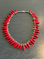 Full view of necklace laid flat showing chili pepper beads and clasp