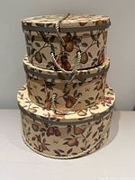 Three nesting pear print hat boxes stacked front view