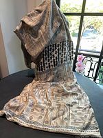 Full length view of patterned shawl draped to show front designs and solid back