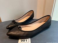 Side profile of both shoes showing leather uppers and bow