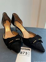 Top view of both shoes showing bow, pointed toes, Ferragamo insole logo, lot reference tag