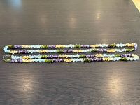 Both gemstone chip necklaces laid out full length