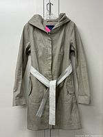 Full front view of trench coat hanging, showing hood, belt, pockets