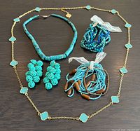 All four jewelry pieces arranged on surface