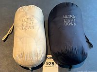 Two fabric pouches labeled ULTRA LIGHT DOWN in beige and black