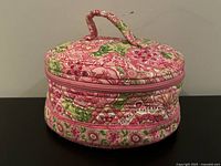 Front view of round pink floral quilted Vera Bradley makeup bag