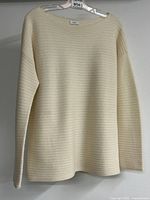 Front view of cream ribbed cashmere sweater on hanger