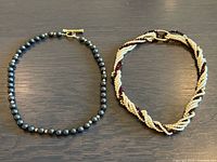 Both necklaces laid flat showing overall design