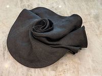 Top view of black ribbed fabric hat showing swirl design