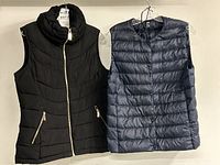 Front view of both puffer vests hanging side by side