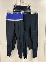 Front view of two pairs of leggings plus partial third pair