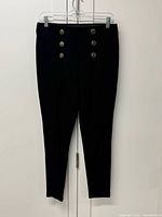 Full view of black stretch pants hung on hanger