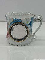 Side view showing inset mirror, handle, floral design and gilt details