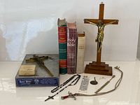 Group showing crucifixes, bibles, rosaries, medal, box