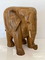 Full view of teak elephant sculpture standing on all four legs