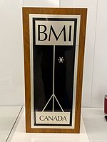Front view of BMI Canada sign in walnut frame