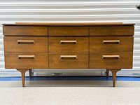 Front view of dresser showing all nine drawers and legs