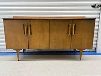 Front view of solid birch credenza showing four doors and tapered legs