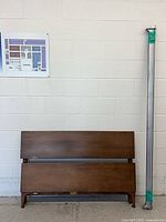 headboard, footboard and one metal rail leaning against wall