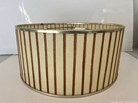 Front view of drum lampshade showing teak strips and brass-tone rim