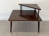 Front view showing both tiers, legs, and brass caps