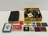 Overview of both boxes of matchbooks and two playing card decks